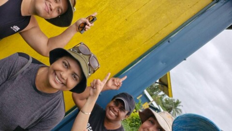 Group of people standing infront of a home they built.