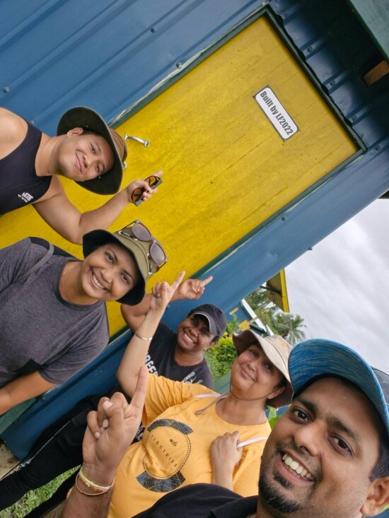 Group of people standing infront of a home they built.